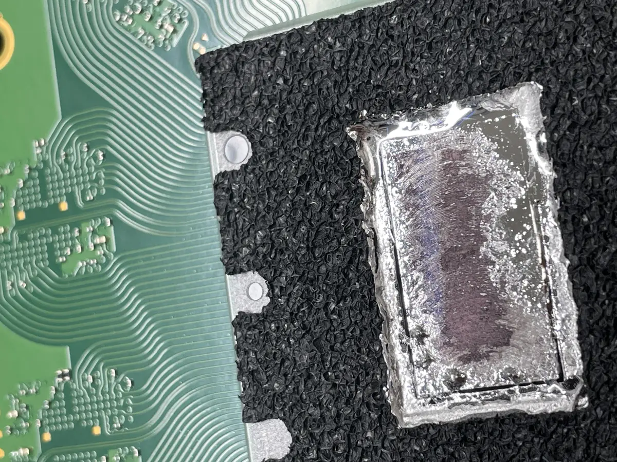Close-up of a PS5 heatsink and liquid metal thermal compound during a bench repair