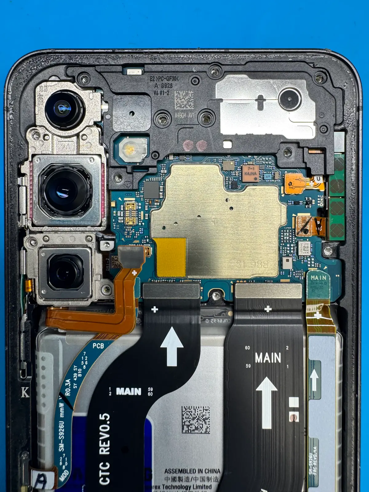 Close-up of an opened Android phone's camera modules and mainboard during repair