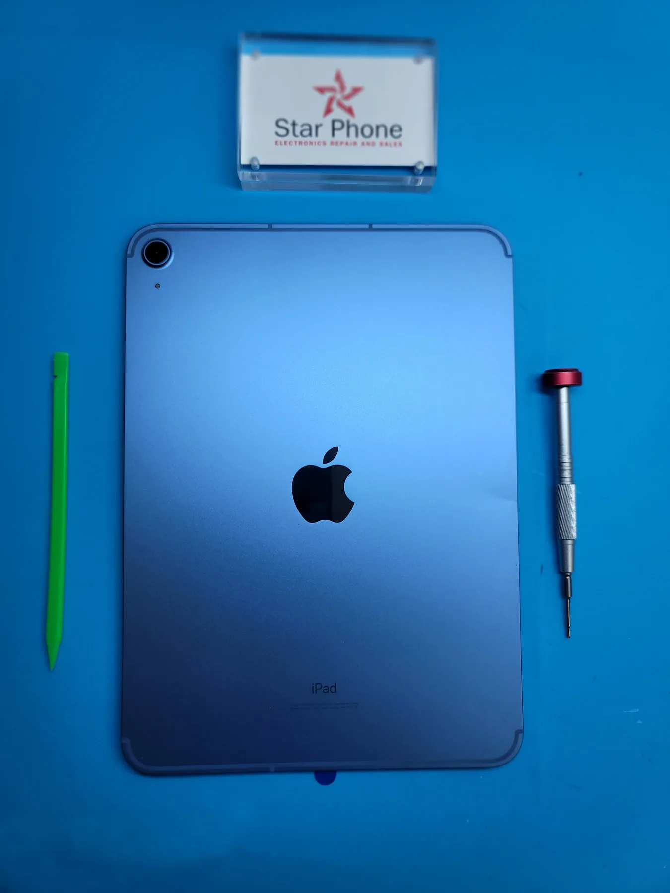Technician holding a shattered iPad screen glass removed during tablet repair